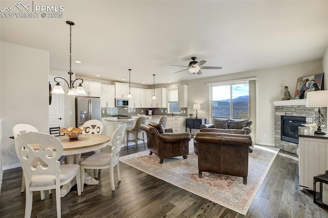 2062 Lone Willow Vw, Colorado Springs, CO 80904 - living area with a stone fireplace, ceiling fan, dark wood-type flooring, recessed lighting, and baseboards