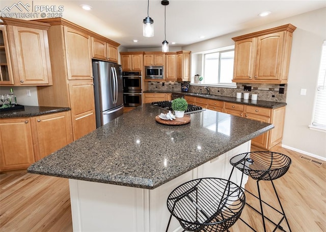 12515 Broad Oaks Dr, Colorado Springs, CO 80921 - kitchen featuring stainless steel appliances, a kitchen bar, light wood-style flooring, a center island, and recessed lighting