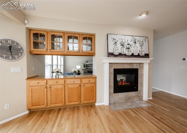 12515 Broad Oaks Dr, Colorado Springs, CO 80921 - bar area featuring light wood-style floors, a fireplace, and baseboards