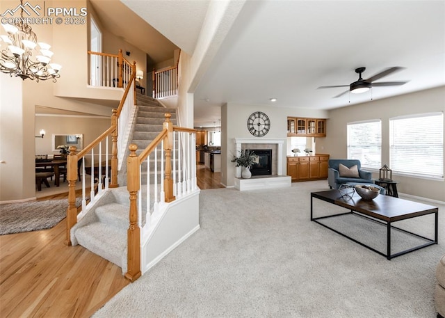 12515 Broad Oaks Dr, Colorado Springs, CO 80921 - living area featuring baseboards, stairway, a ceiling fan, a chandelier, and a tiled fireplace