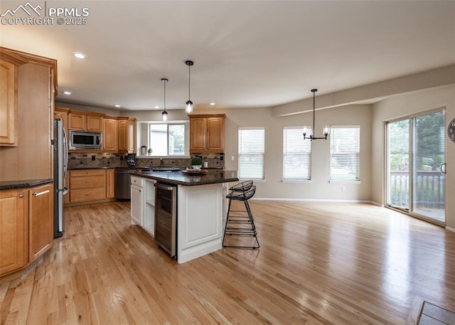 12515 Broad Oaks Dr, Colorado Springs, CO 80921 - kitchen with appliances with stainless steel finishes, wine cooler, a breakfast bar, light wood-style floors, and recessed lighting