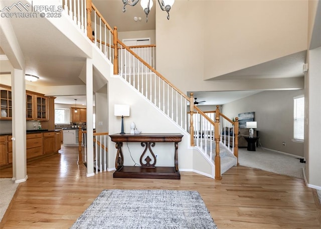 12515 Broad Oaks Dr, Colorado Springs, CO 80921 - foyer entrance with stairs, light wood-style flooring, a high ceiling, baseboards, and a chandelier