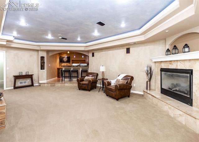 12515 Broad Oaks Dr, Colorado Springs, CO 80921 - carpeted living room with a raised ceiling, a fireplace, arched walkways, baseboards, and recessed lighting
