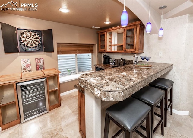 12515 Broad Oaks Dr, Colorado Springs, CO 80921 - kitchen featuring beverage cooler, brown cabinetry, baseboards, glass insert cabinets, and a kitchen breakfast bar