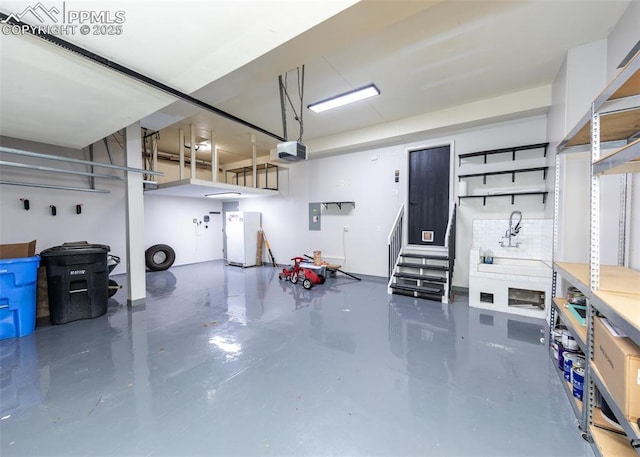 12515 Broad Oaks Dr, Colorado Springs, CO 80921 - garage featuring a garage door opener and freestanding refrigerator