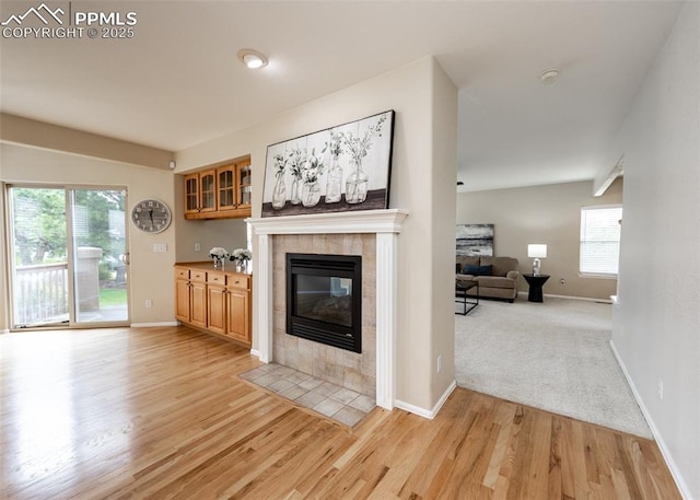 12515 Broad Oaks Dr, Colorado Springs, CO 80921 - living room with a tile fireplace, light wood finished floors, and baseboards