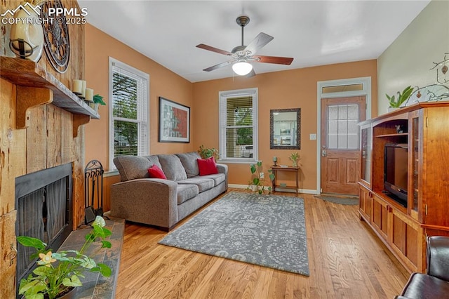 115 N 24th St, Colorado Springs, CO 80904 - living area with plenty of natural light, wood finished floors, a ceiling fan, and a fireplace