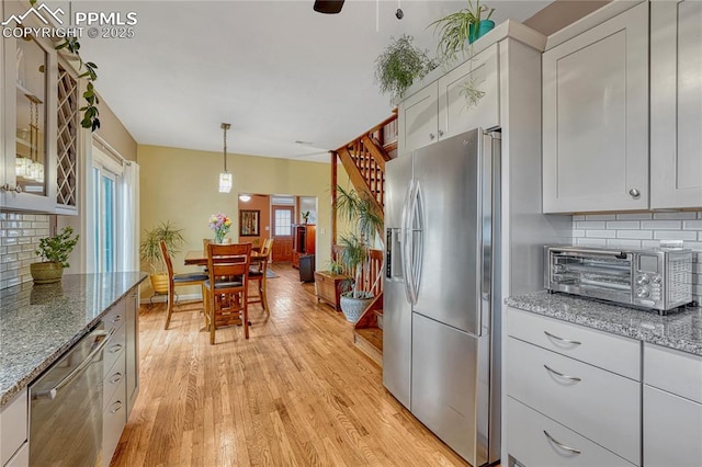 115 N 24th St, Colorado Springs, CO 80904 - kitchen featuring stainless steel appliances, backsplash, light wood-style flooring, and white cabinets