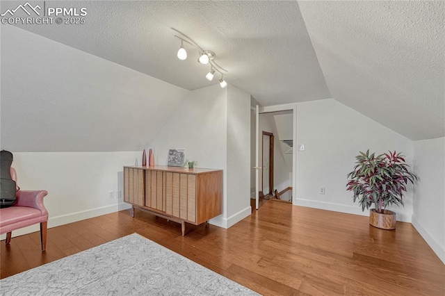 115 N 24th St, Colorado Springs, CO 80904 - sitting room with wood finished floors, vaulted ceiling, a textured ceiling, and baseboards
