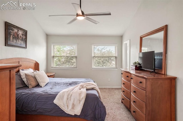 bedroom with light colored carpet, baseboards, vaulted ceiling, and a ceiling fan