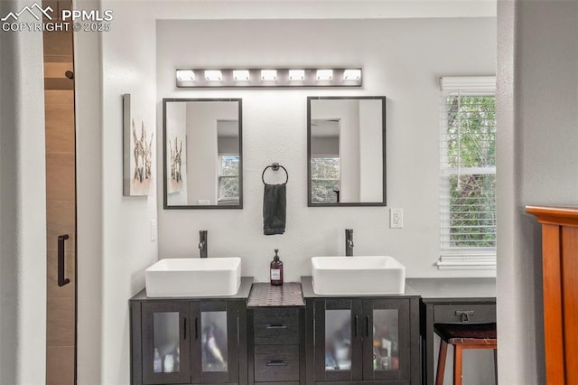 full bath featuring double vanity and a tile shower