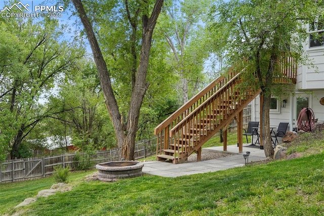 view of yard featuring an outdoor fire pit, stairway, and a patio