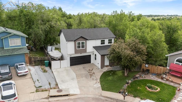 view of front of home with a garage, a shingled roof, concrete driveway, and a view of trees