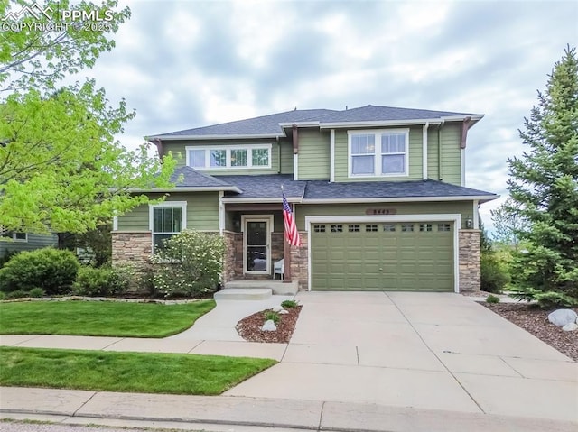 8445 Jacks Fork Dr, Colorado Springs, CO 80924 - view of front facade with concrete driveway, a garage, stone siding, and a front yard