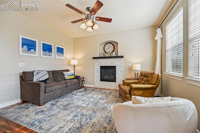 8445 Jacks Fork Dr, Colorado Springs, CO 80924 - living area featuring ceiling fan, baseboards, wood finished floors, and a fireplace