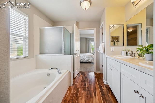 8445 Jacks Fork Dr, Colorado Springs, CO 80924 - ensuite bathroom with double vanity, plenty of natural light, a bath, and wood finished floors