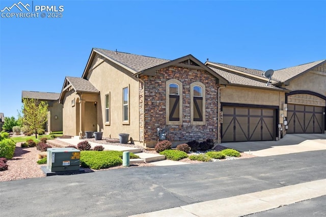 7663 Double Barrel Hts, Colorado Springs, CO 80923 - view of front of property with a garage, stucco siding, stone siding, and concrete driveway