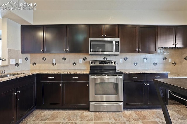 7719 Paca Pl, Fountain, CO 80817 - kitchen with stainless steel appliances, a sink, decorative backsplash, and light stone counters