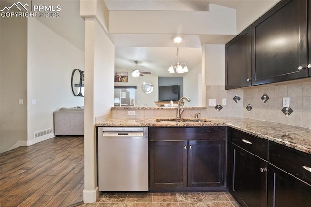 7719 Paca Pl, Fountain, CO 80817 - kitchen with stainless steel dishwasher, a sink, light stone counters, a chandelier, and tasteful backsplash
