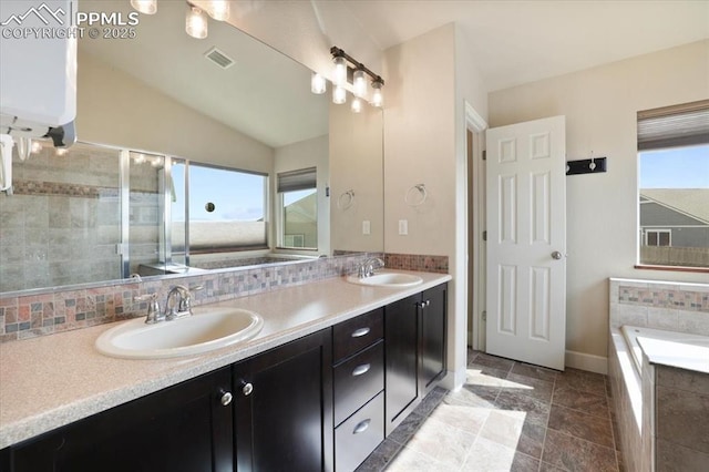 7719 Paca Pl, Fountain, CO 80817 - bathroom with healthy amount of natural light, double vanity, water heater, vaulted ceiling, and a garden tub