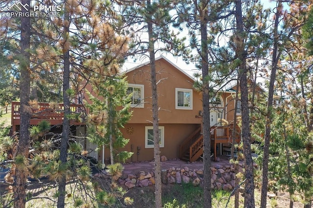 1053 Kings Crown Rd, Woodland Park, CO 80863 - rear view of property featuring stucco siding, stairway, and a deck
