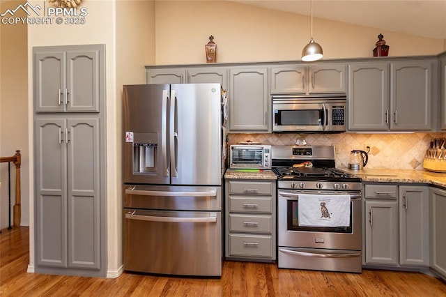 1053 Kings Crown Rd, Woodland Park, CO 80863 - kitchen featuring stainless steel appliances, gray cabinetry, lofted ceiling, light wood finished floors, and decorative backsplash