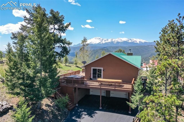 1053 Kings Crown Rd, Woodland Park, CO 80863 - back of property with a deck with mountain view, metal roof, and stucco siding