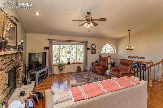 1053 Kings Crown Rd, Woodland Park, CO 80863 - living room featuring a chandelier, a ceiling fan, a stone fireplace, wood finished floors, and lofted ceiling