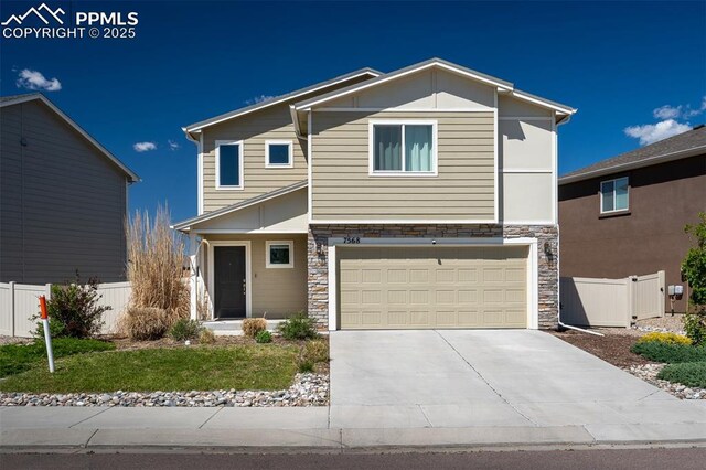 7568 Benecia Dr, Fountain, CO 80817 - view of front of house with stone siding, a garage, and driveway
