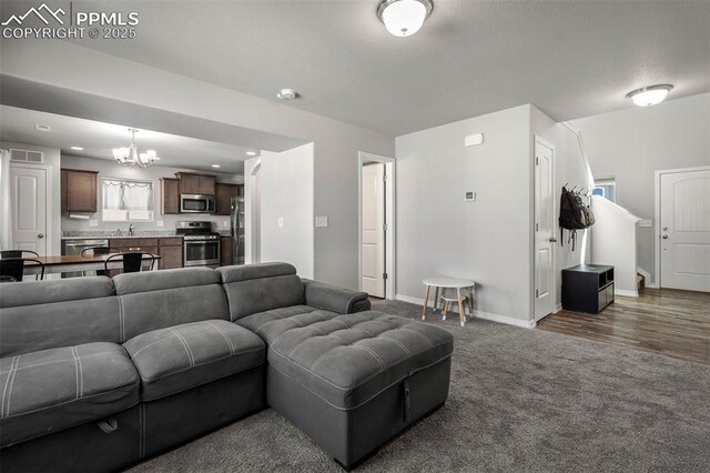 7568 Benecia Dr, Fountain, CO 80817 - carpeted living room featuring a chandelier, baseboards, a sink, and recessed lighting
