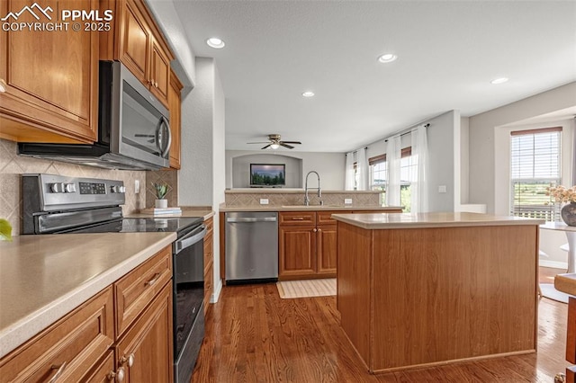 9883 Red Sage Dr, Colorado Springs, CO 80920 - kitchen with stainless steel appliances, a sink, dark wood finished floors, brown cabinets, and recessed lighting