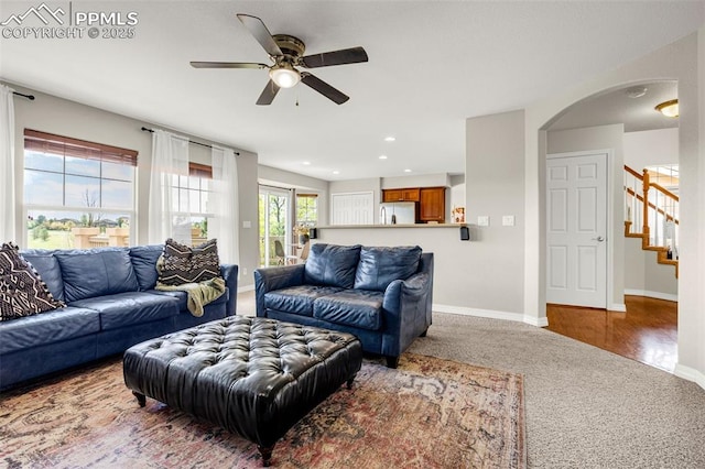 9883 Red Sage Dr, Colorado Springs, CO 80920 - living room with carpet, a ceiling fan, baseboards, stairway, and arched walkways