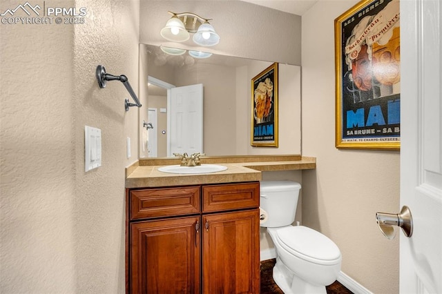 9883 Red Sage Dr, Colorado Springs, CO 80920 - half bath with toilet, vanity, a textured wall, and baseboards