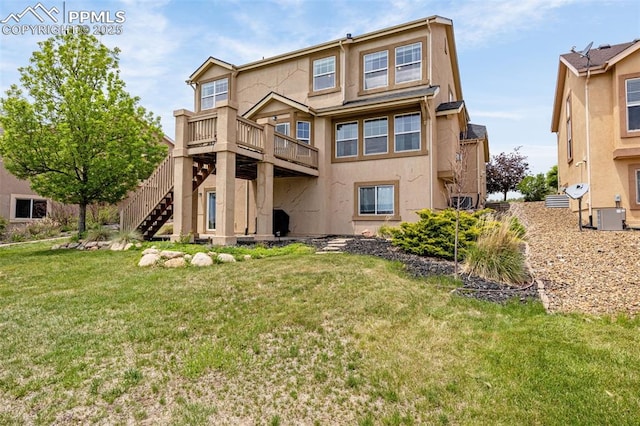 9883 Red Sage Dr, Colorado Springs, CO 80920 - back of property with stucco siding, stairway, a lawn, a deck, and cooling unit