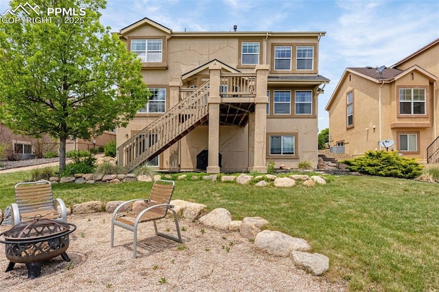 9883 Red Sage Dr, Colorado Springs, CO 80920 - rear view of house featuring a fire pit, stairway, a yard, and stucco siding