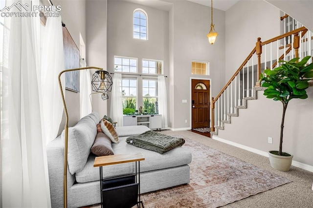 9883 Red Sage Dr, Colorado Springs, CO 80920 - living area with stairway, a high ceiling, carpet floors, and baseboards