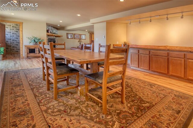 65 Sunshine Loop, Fairplay, CO 80440 - dining area with rail lighting, light wood finished floors, a fireplace, and recessed lighting
