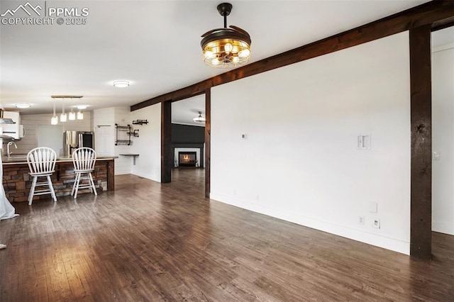 527 Golden Grain Ln, Divide, CO 80814 - living room featuring dark wood-style flooring, baseboards, and a warm lit fireplace
