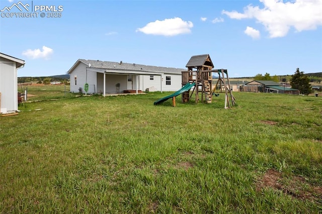 527 Golden Grain Ln, Divide, CO 80814 - rear view of house featuring a playground and a lawn