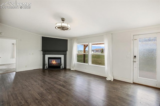 527 Golden Grain Ln, Divide, CO 80814 - unfurnished living room featuring crown molding, dark wood-style flooring, a glass covered fireplace, baseboards, and vaulted ceiling