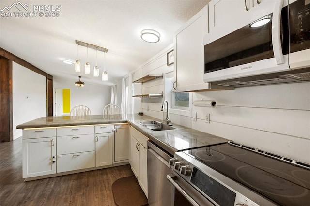 527 Golden Grain Ln, Divide, CO 80814 - kitchen featuring appliances with stainless steel finishes, a sink, a peninsula, dark wood-style floors, and open shelves