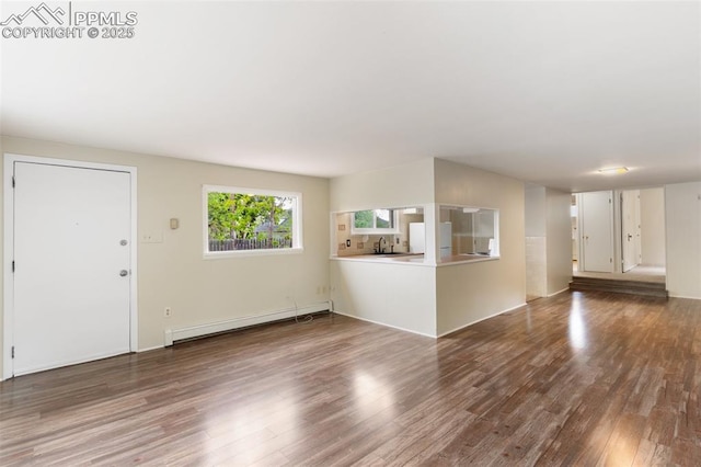 15 W Brookside St, Colorado Springs, CO 80905 - unfurnished living room featuring a baseboard heating unit and wood finished floors
