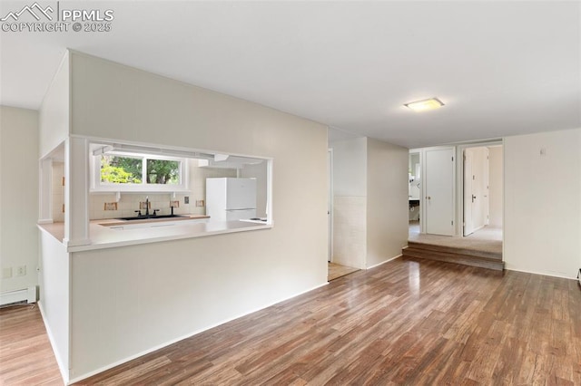 15 W Brookside St, Colorado Springs, CO 80905 - unfurnished living room with a sink, wood finished floors, and a baseboard radiator