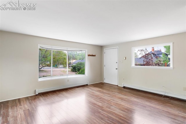 15 W Brookside St, Colorado Springs, CO 80905 - unfurnished room featuring a baseboard heating unit, healthy amount of natural light, and wood finished floors