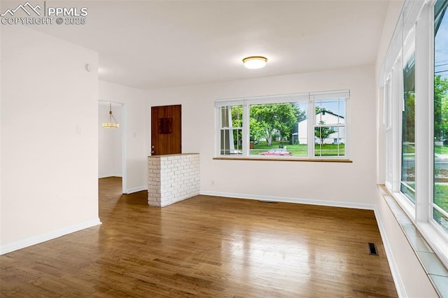 1604 E Kiowa St, Colorado Springs, CO 80909 - unfurnished living room featuring wood finished floors and baseboards