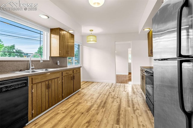 1604 E Kiowa St, Colorado Springs, CO 80909 - kitchen featuring black appliances, light wood-type flooring, decorative backsplash, brown cabinets, and hanging light fixtures