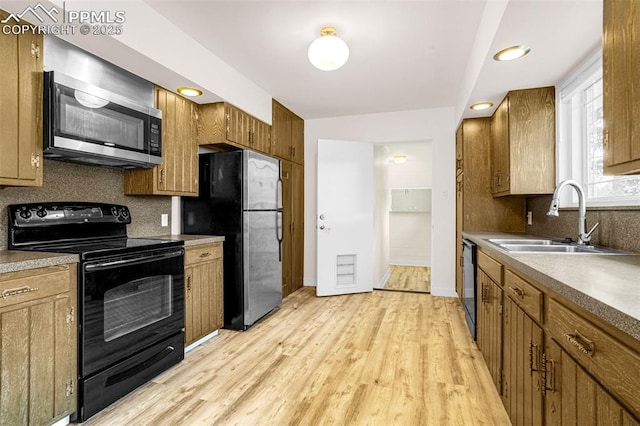 1604 E Kiowa St, Colorado Springs, CO 80909 - kitchen with black appliances, decorative backsplash, light wood-type flooring, and brown cabinets