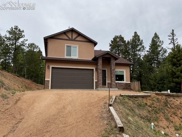 71 Mt Elbert Dr, Florissant, CO 80816 - view of front of house featuring stone siding, an attached garage, stucco siding, and dirt driveway