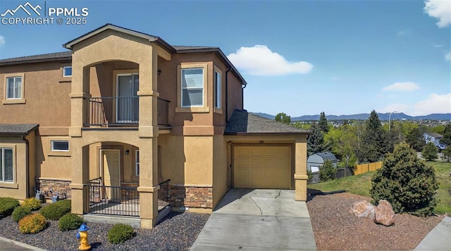 4807 Kerry Lynn Vw Unit 102, Colorado Springs, CO 80922 - view of front facade with a balcony, a mountain view, stucco siding, concrete driveway, and stone siding