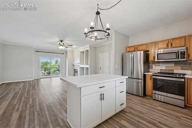 4807 Kerry Lynn Vw Unit 102, Colorado Springs, CO 80922 - kitchen with appliances with stainless steel finishes, a lit fireplace, dark wood finished floors, a chandelier, and crown molding